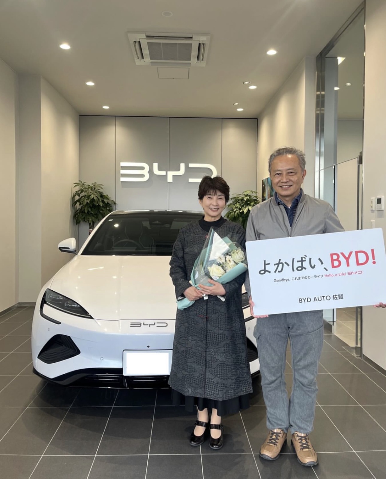 Customer holding key next to BYD car