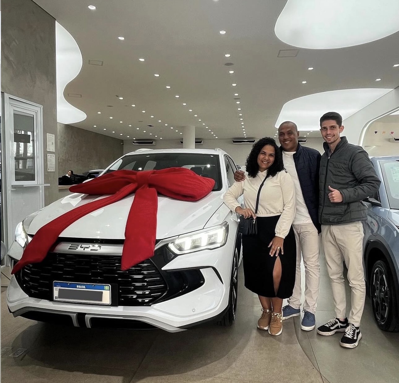 Two people standing next to BYD car outside dealership